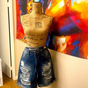 Ripped / distressed jeans. Mid thigh length.